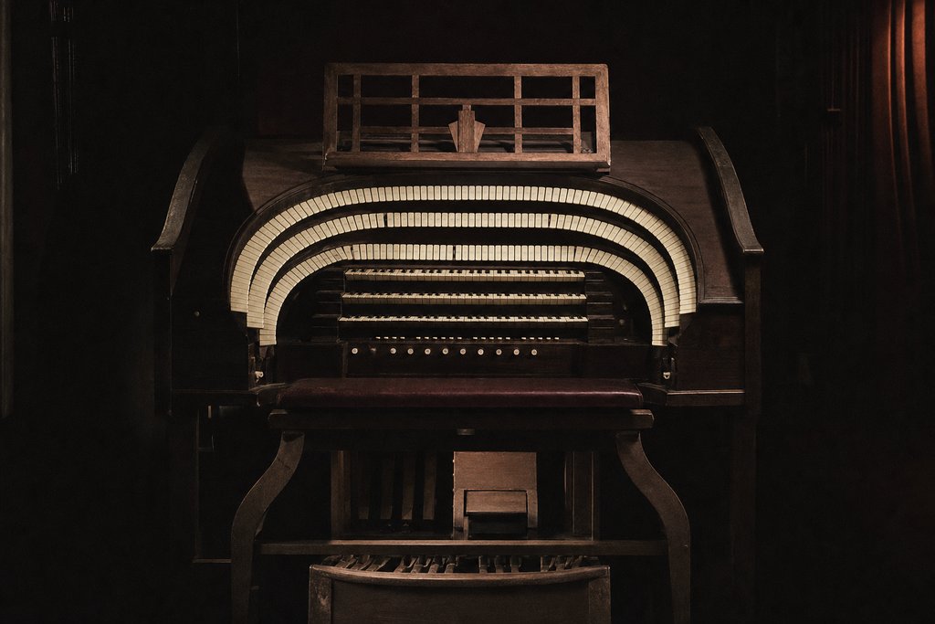 A cinema organ console, the horseshoe of stop tabs curving around an empty bench.